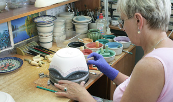 素焼きした陶器を台にセットして絵付けをします。
